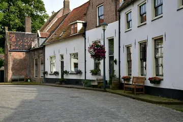 A cobblestone street lined with white buildings.